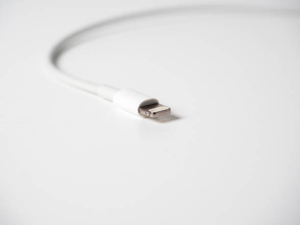 istock Close-up of a white lightning cable isolated on a white background. Cable for charging gadgets and transmitting information 2109330043