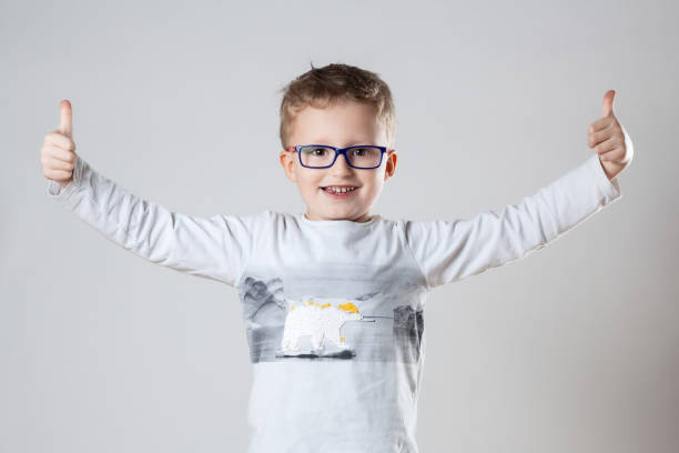 istock A young boy, wearing glasses, enthusiastically gives a thumbs up gesture 2109336730