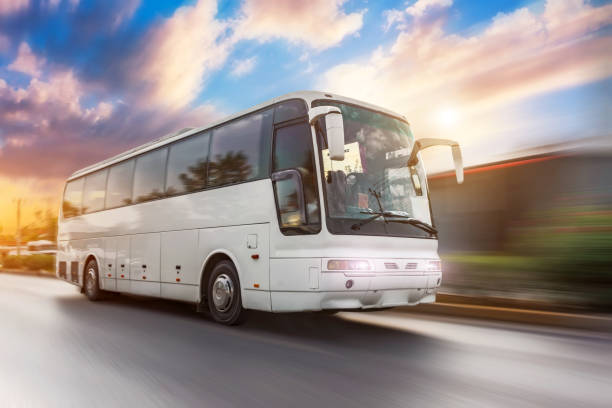 istock Bus driving moving at high motion blur effect speed on a road in the sunset. 2109346351