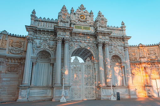 Sunset shot of closed gate leading former Ottoman Dolmabahce Palace, suited Ciragan Street, Besiktas distric. Gate contains monogram of Sultan Abd lmecid Underneath is a poem by Ziver dated 1855