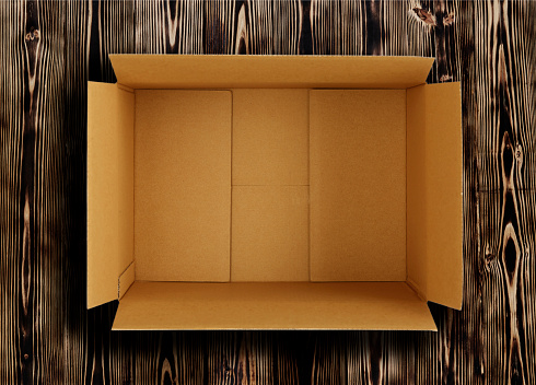 High quality opened rectangular blank empty cardboard brown box isolated on wooden background. Front view angle. Closeup studio shot for postal delivery and suitable for food, cosmetic or medical packaging.