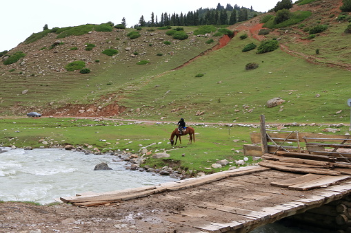 August 28 2023 - Jeti Oguz, Issyk-Kul Region in Kyrgyzstan: locals riding horses in the mountains on a cloudy day