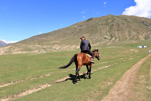 August 31 2023 - Semyonovka, Kyrchyn Valley in Kyrgyzstan: People riding horses in north of Kyrgyzstan mountains