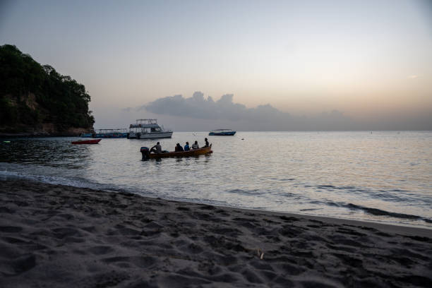 istock Sunset at Paradise beach on Saint Lucia with boat floating on water 2109519517
