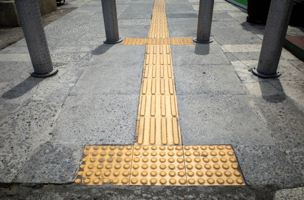 Yellow tactile paving for blind people or visually impaired on the sidewalk.