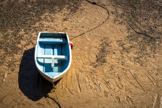A small boat at low tide in the harbor