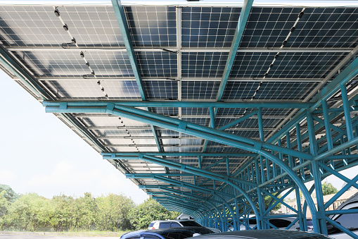 Solar car parking or parking lot at outdoor. Roof canopy covered or construction from solar panel. Innovation system technology to generate electricity from light. Concept of green clean power energy.