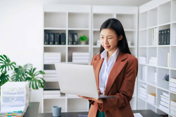 istock A woman in a business suit is looking at a laptop computer 2109609549