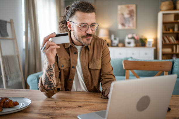 istock Handsome man shopping online or checking bank account using laptop 2109643626