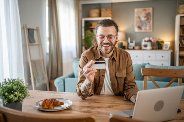 istock Handsome man shopping online or checking bank account using laptop 2109643636