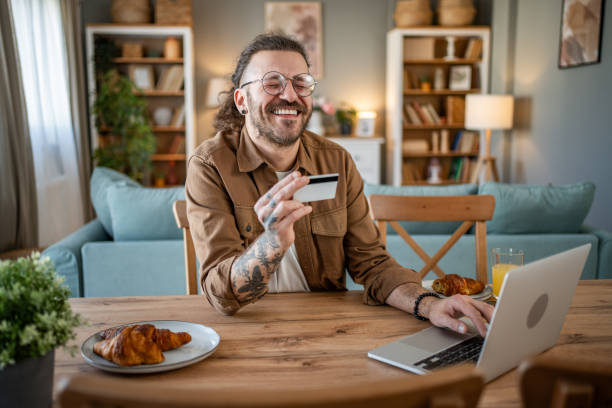 istock Handsome man shopping online or checking bank account using laptop 2109643747