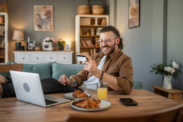 istock Handsome man shopping online or checking bank account using laptop 2109646310