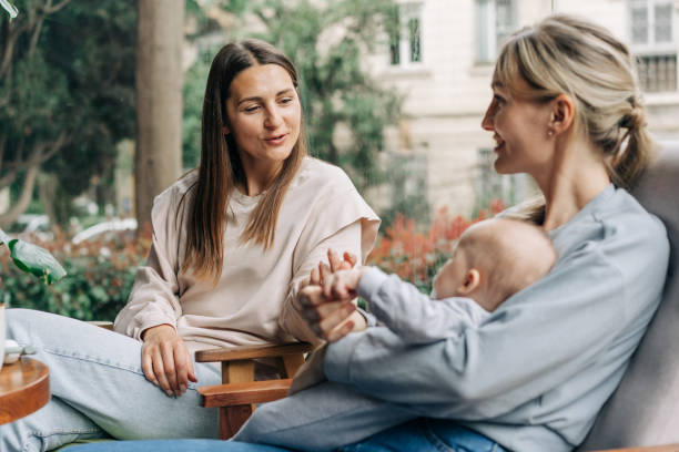 istock Two women talk about motherhood while nursing a baby while sitting in a cafe. 2109649401