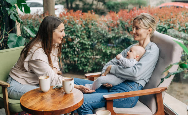 istock Two women talk about motherhood while nursing a baby while sitting in a cafe. 2109649417