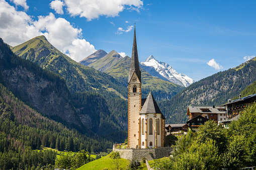 Heiligenblut, Carinthia, Austria, A scenic landscape photo of the Austrian municipality of Heiligenblut with St. Vincent Church in front of the Hohe Tauern mountain ridge