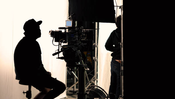 Video production behind the scenes which film crew team in silhouette shooting or recording tv movie commercial with professional equipment such as high definition 4k camera with monitor and tripod or gimbal rig in big studio set. producción de video detrás de escena que el equipo de filmación se une en el rodaje de siluetas o la grabación de comerciales de películas de televisión con equipos profesionales como una cámara 4k de alta definición con monitor y trípode o una pl