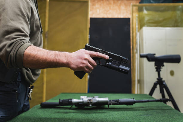 istock A pistol with a weapon flashlight in a man's hand at a shooting range. 2109720477