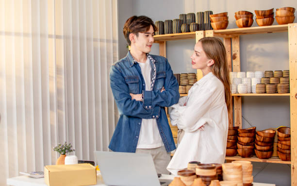 sweet successful couple wearing casual clothes, smiling, online selling, posing together, doing own business or entrepreneurship at indoor home. e-commerce concept. - e commerce couple working at home internet zdjęcia i obrazy z banku zdjęć