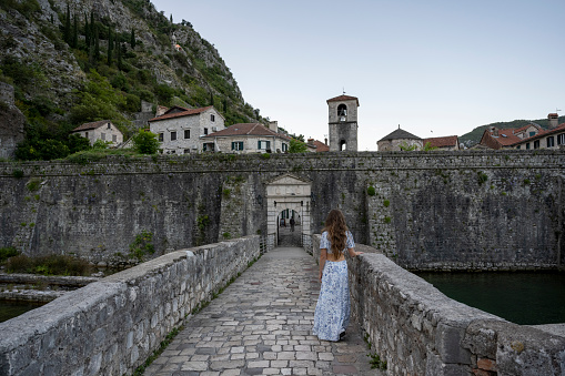 Woman walks across stone bridge in old town