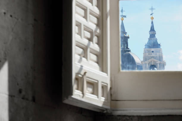 Sunlight illuminating a sophisticated window with white shutters and intricate architectural details on a building in Buenos Aires, Argentina, showcasing the city's rich architectural heritage