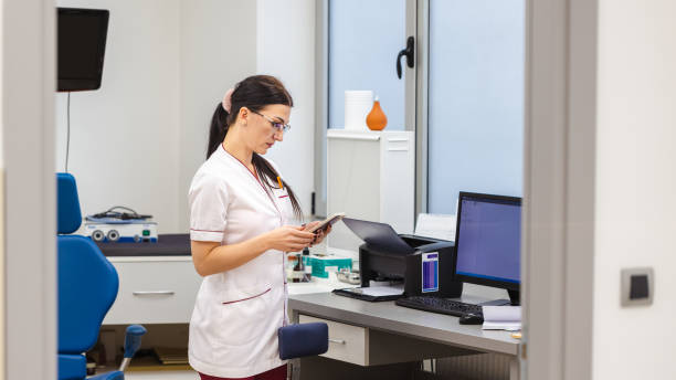 at the ent clinic, nurse use app on mobile phone, to adjust medical instrument and equipments for an medical exam - telephone doctor medical exam healthcare and medicine imagens e fotografias de stock