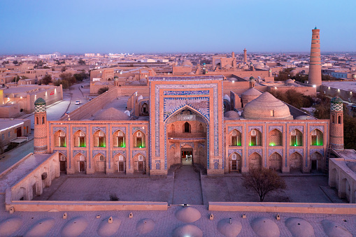Itchan Kala Khiva City Uzbekistan Drone View over Khiva - Xiva - Хива, famous City along the Silk Road with majestic the Itchan Kala, Mohammed Rakhim Khan Madrassah Islamic School Complex and the Islam Khoja Minaret in the background. Colourful Sunset Twilght over the Madressa Complex in Itchan Kala, Khiva - Chiva, Xorazm Region, Uzbekistan, Central Asia