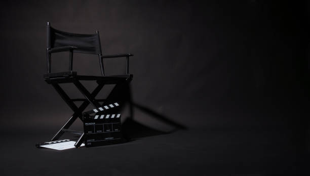 istock Black Director chair and two clapper board with light an shadow on black background. 2109879064