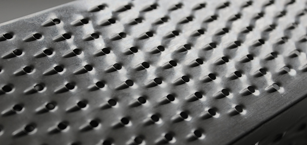 One of the sides of a square kitchen food grater
