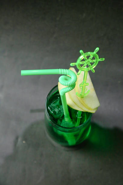 A photo capturing a green drink with a green straw, showcasing a refreshing beverage.