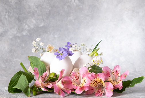 Easter composition in a natural style. creative easter floral arrangements with alstroemeria and eggs in the nest. Copy space