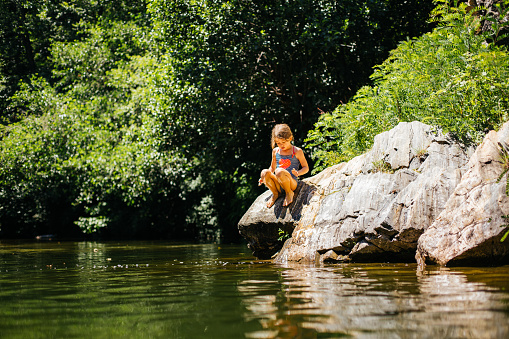 Girl having fun on her summer vacation , swimming in the river