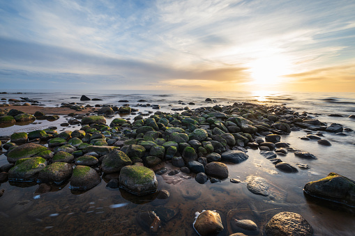 A long exposure shot of the beach rocks of Vidzeme rocky beach on a springtime sunset