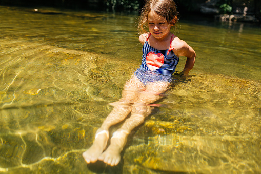 Girl having fun on her summer vacation , swimming in the river