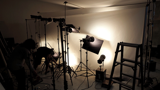 Lighting setup in studio for commercial works such as photo movie or video film production which use many LED light more than 1000 watts with big softbox snoot reflector umbrella and tripods.