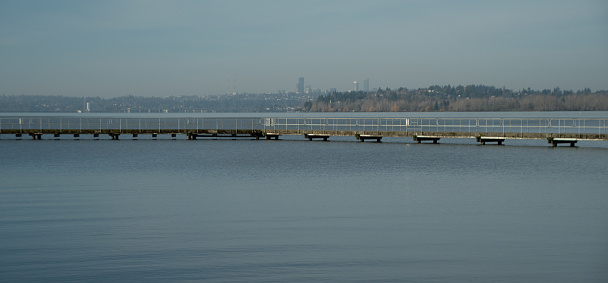 Looking at Juanita  Beach Pier with Seattle downtown in the background right after sunrise on a sunny morning in March