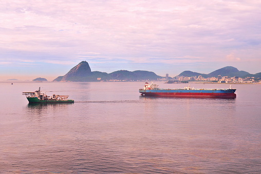 Cargo ships transiting the sea and the Sugar Loaf mountain in the background