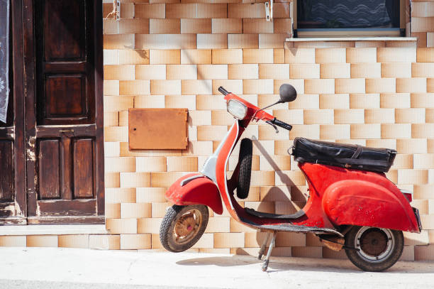 istock Red Vespa near an old house 2110046967