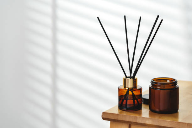 istock Aromatherapy Reed Diffuser and Scented Candle on a Wooden Table in a Cozy Room 2110078704
