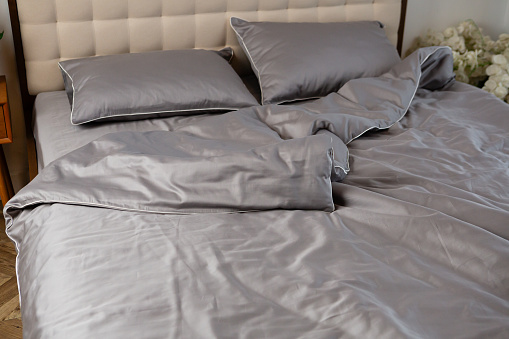 gray cotton satin bed linen on the bed
