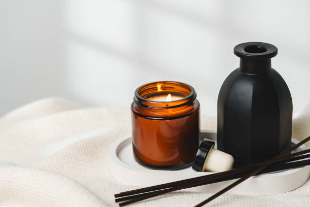 istock Elegant Aroma Diffuser With Reed Sticks And Scented Candle On White Tablecloth 2110098707