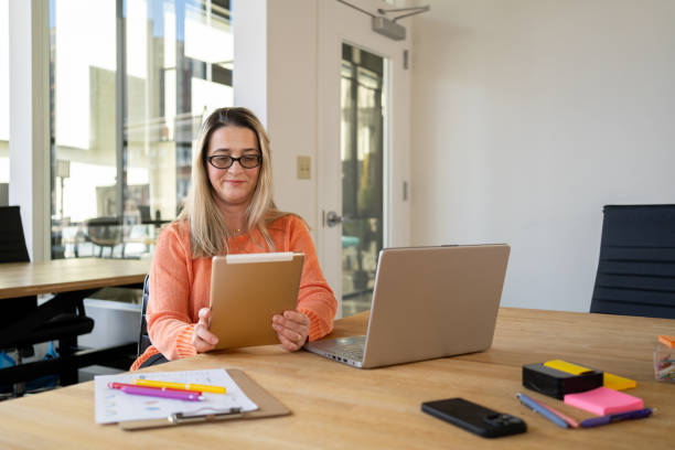 istock Latin woman working at the office using technology 2110130990