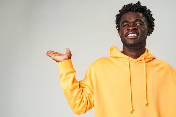 istock Young African Man Pointing at Something Against Gray Background 2110171742