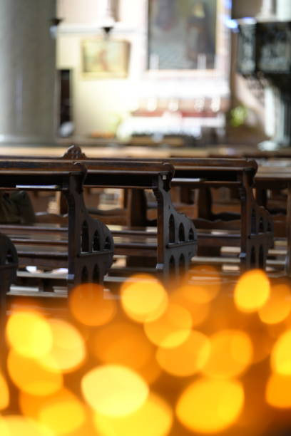 Rows of carved wooden chairs inside an Orthodox church, empty interior with warm light and religious atmosphere.