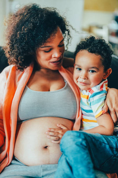 istock Pregnant woman at home having fun with her son 2110207114