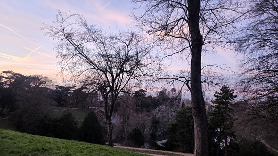 View from above on bridge and gazebo in famous Buttes de Chaumont public park in Paris at dusk in winter