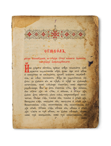 Antique worn sheet from an ancient a 19th century bible. The text is written in old slavic language: Confession of sins in the name of our father Athanasius, Patriarch of Alexandria...