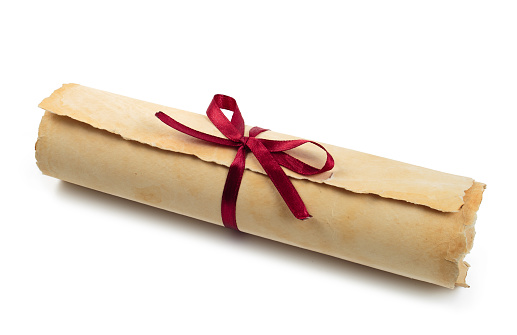 Ancient paper scroll with red ribbon isolated on a white background