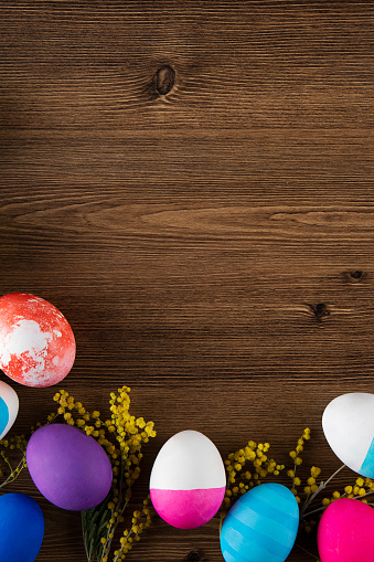 Painted easter eggs on brown wooden background