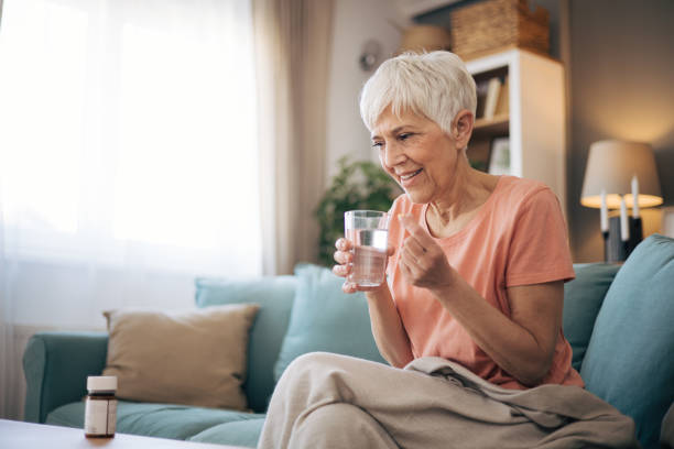 istock Old woman taking her medicine 2110306015