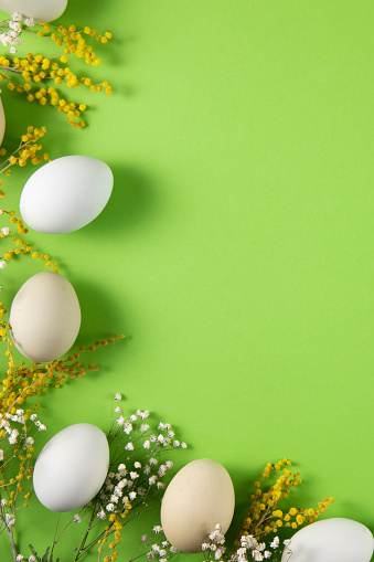 Easter garland, made of flowers and Easter eggs, on wooden background with copy space